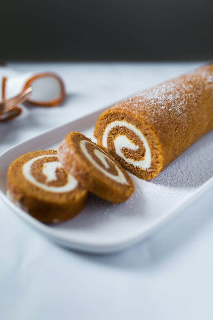 pumpkin roll sitting on a white plate