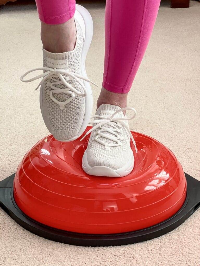 woman wearing easy spirit sneakers on a red balance trainer