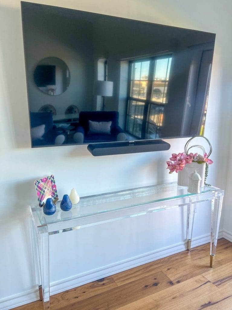 acrylic table under TV in waco loft after remodel