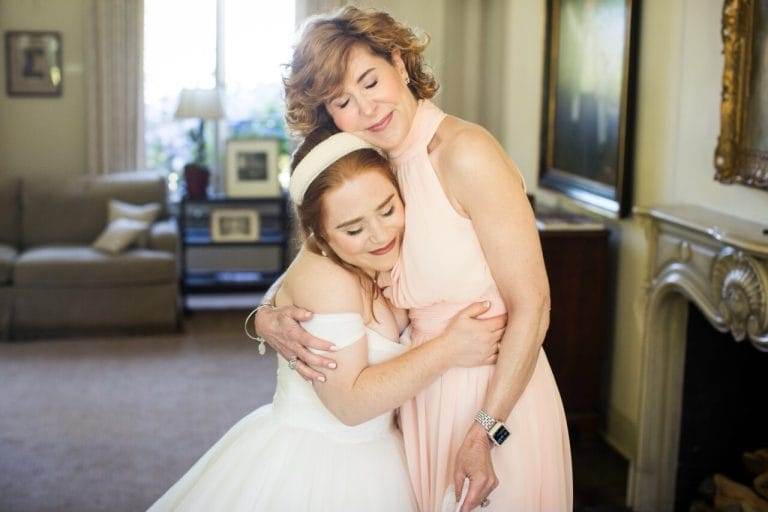 woman over 50 hugging bride