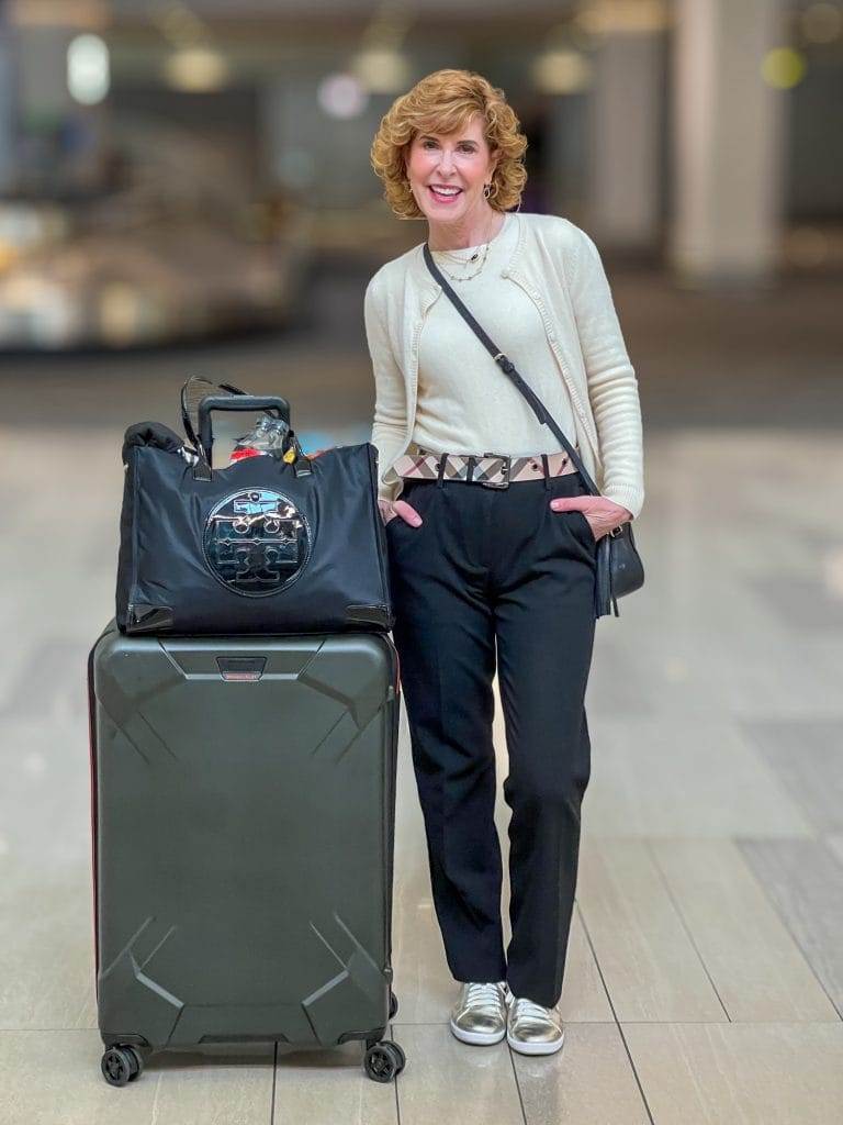 woman in airport wearing travel outfit for nyc