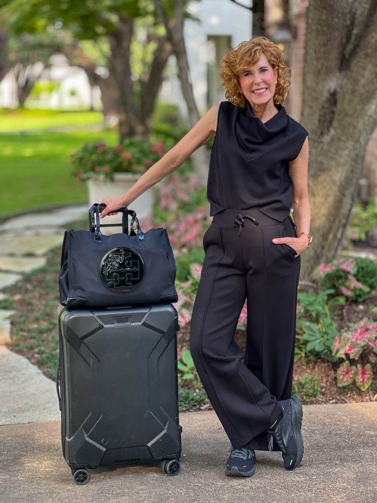 woman standing next to a suitcase in a yard wearing a travel look featuring airknit set from talbots