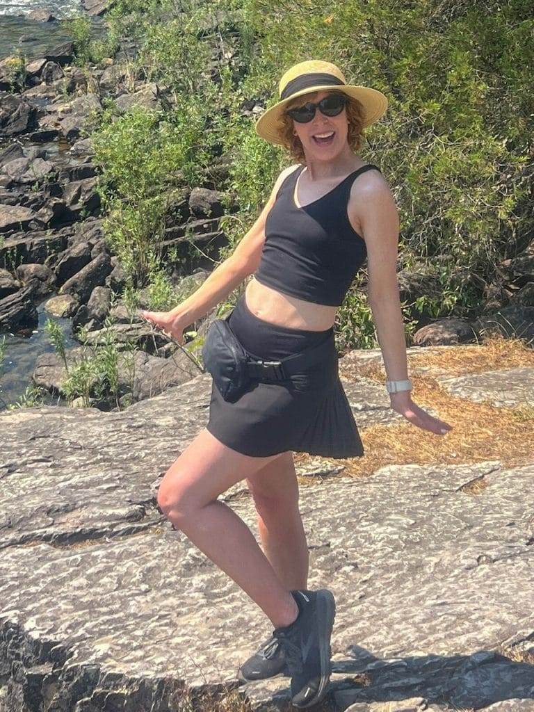 woman in black workout bra and skort near swan river in montana