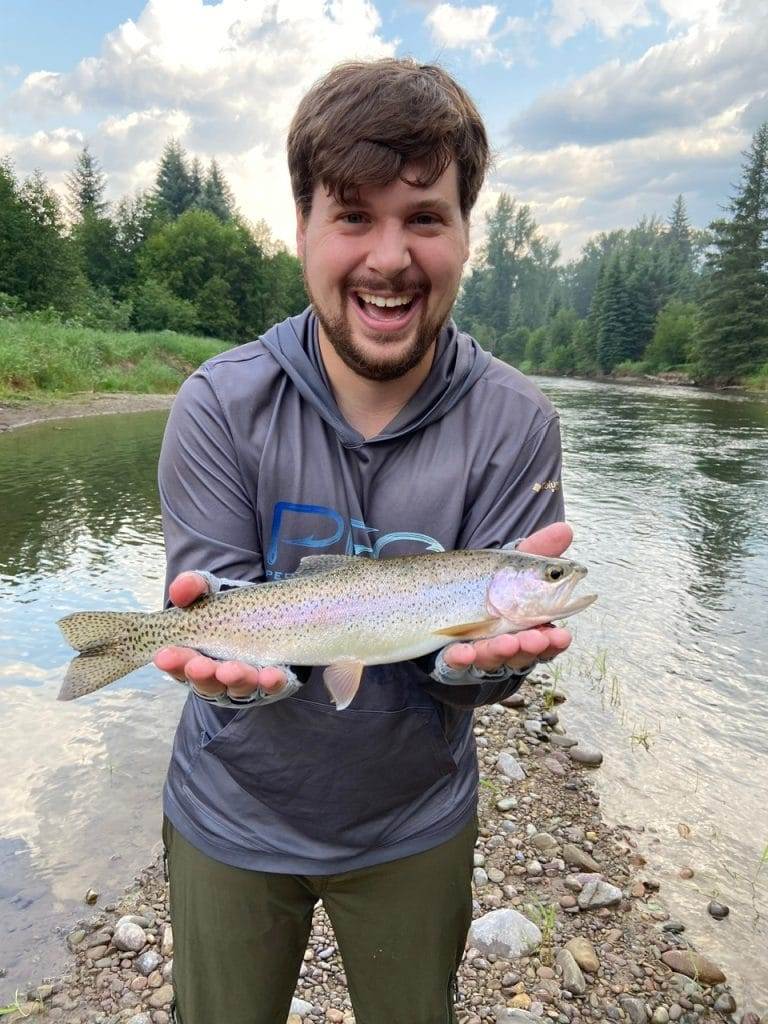 man holding a lake trout he caught