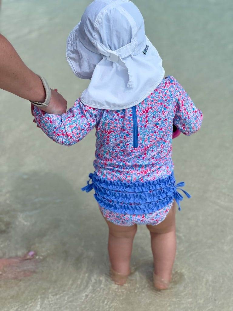 18 month old baby from behind wearing ruffle butts swimsuit