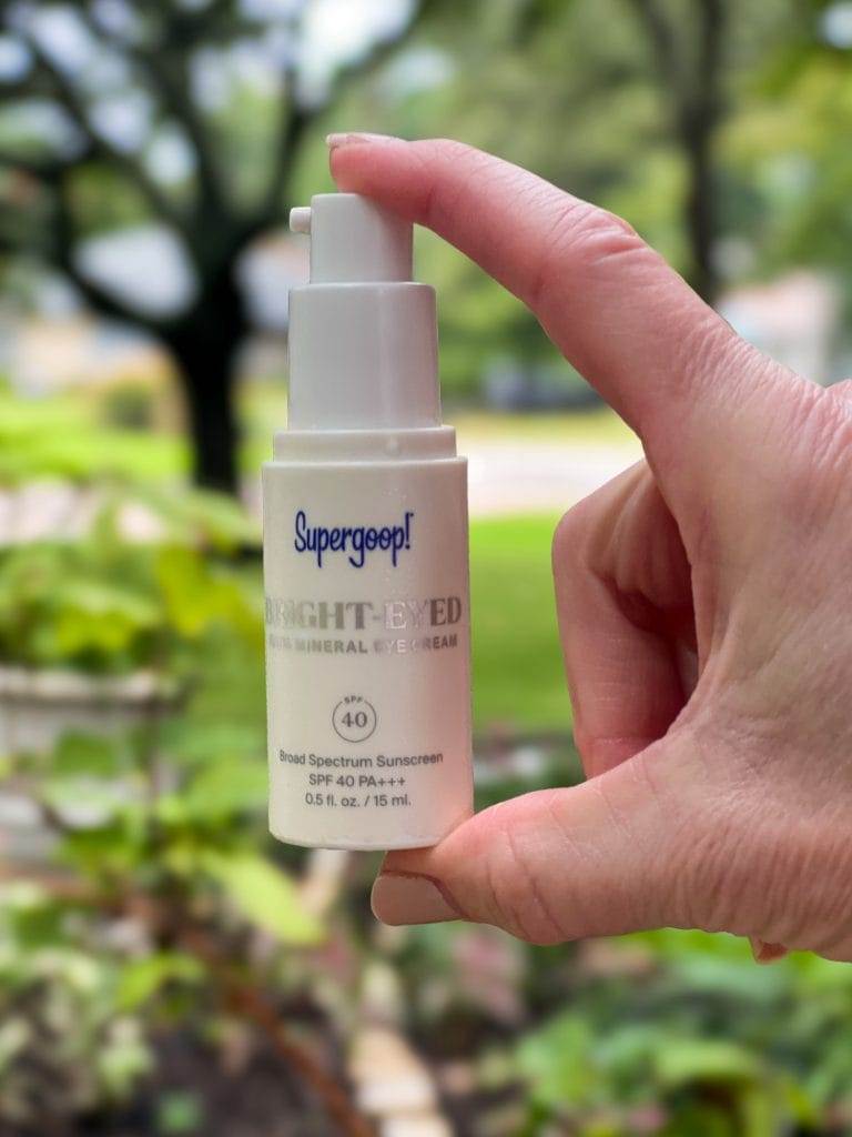 woman's hand holding supergoop under eye sunscreen