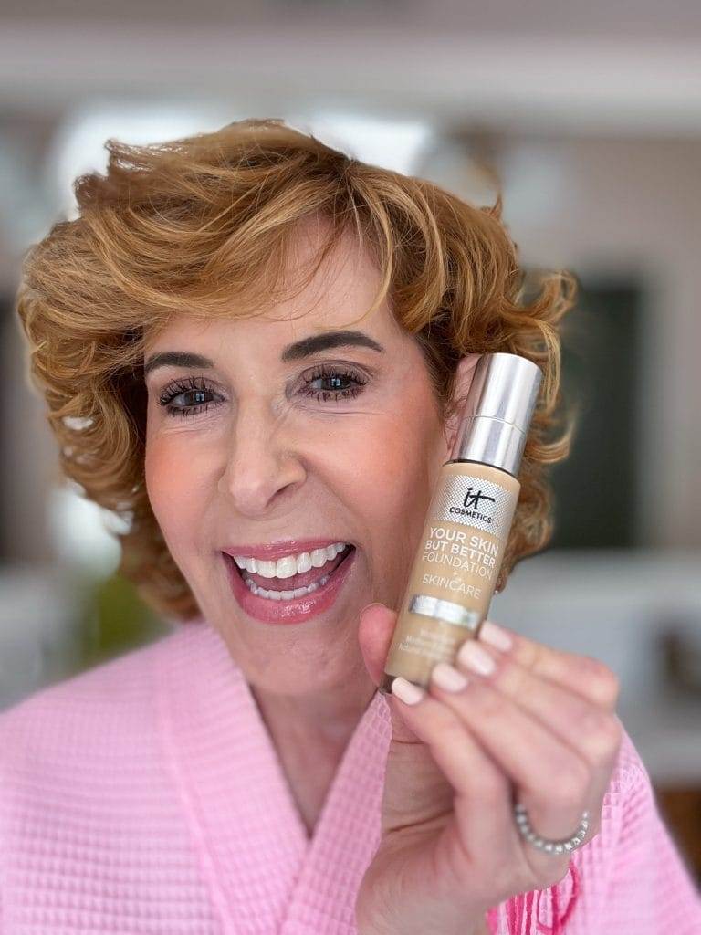 woman over 50 holding her favorite foundation to look younger