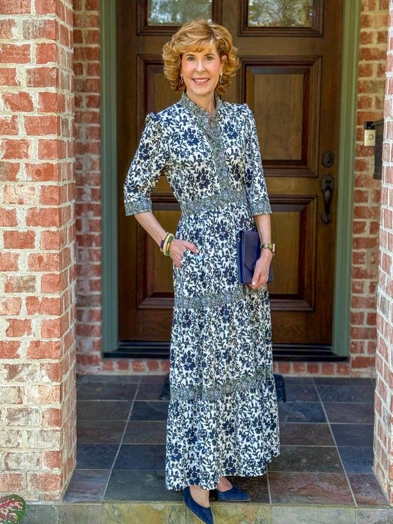 woman standing on porch wearing print dress