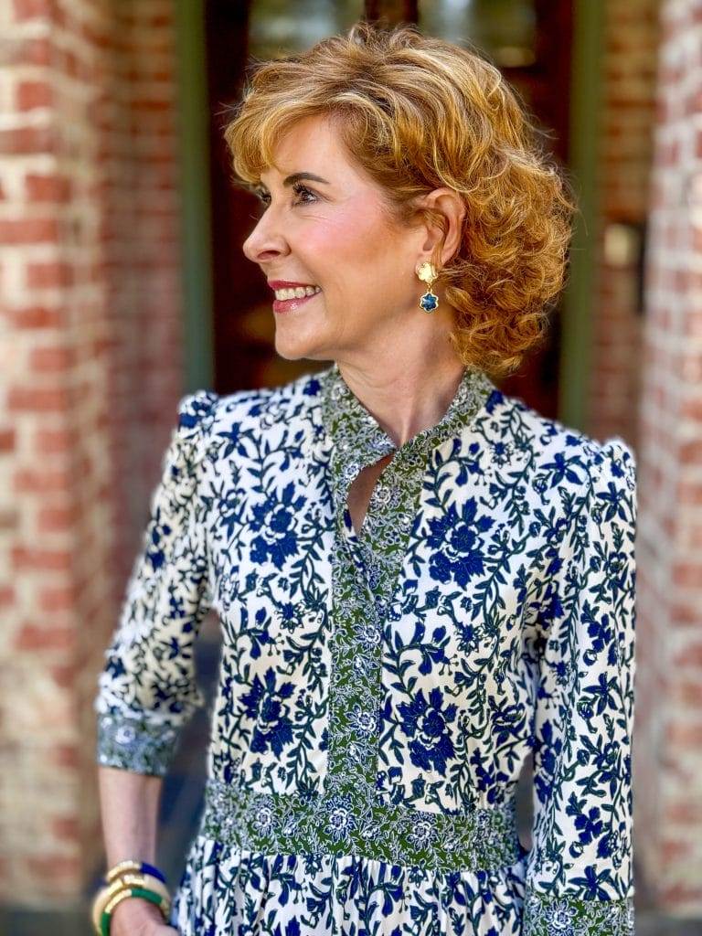 woman from waist up wearing green and blue and cream print dress