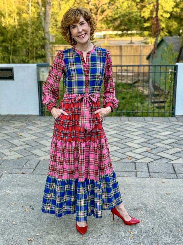 Woman standing out side in plaid Boden maxi dress and red heels