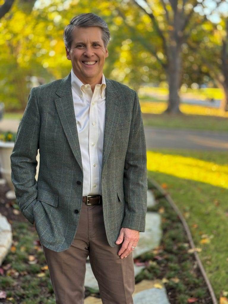 man wearing untuckit blazer standing in front yard