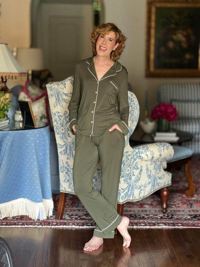 woman standing in living room wearing cozy earth pajamas in green