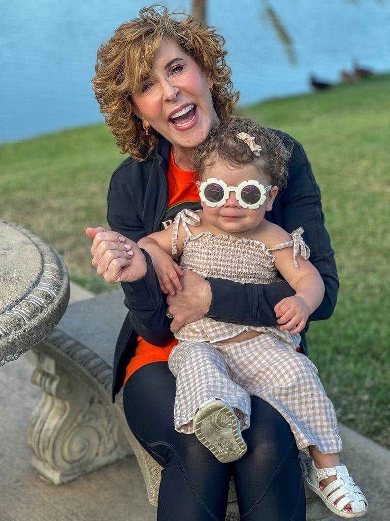 woman holding baby who is wearing sunglasses