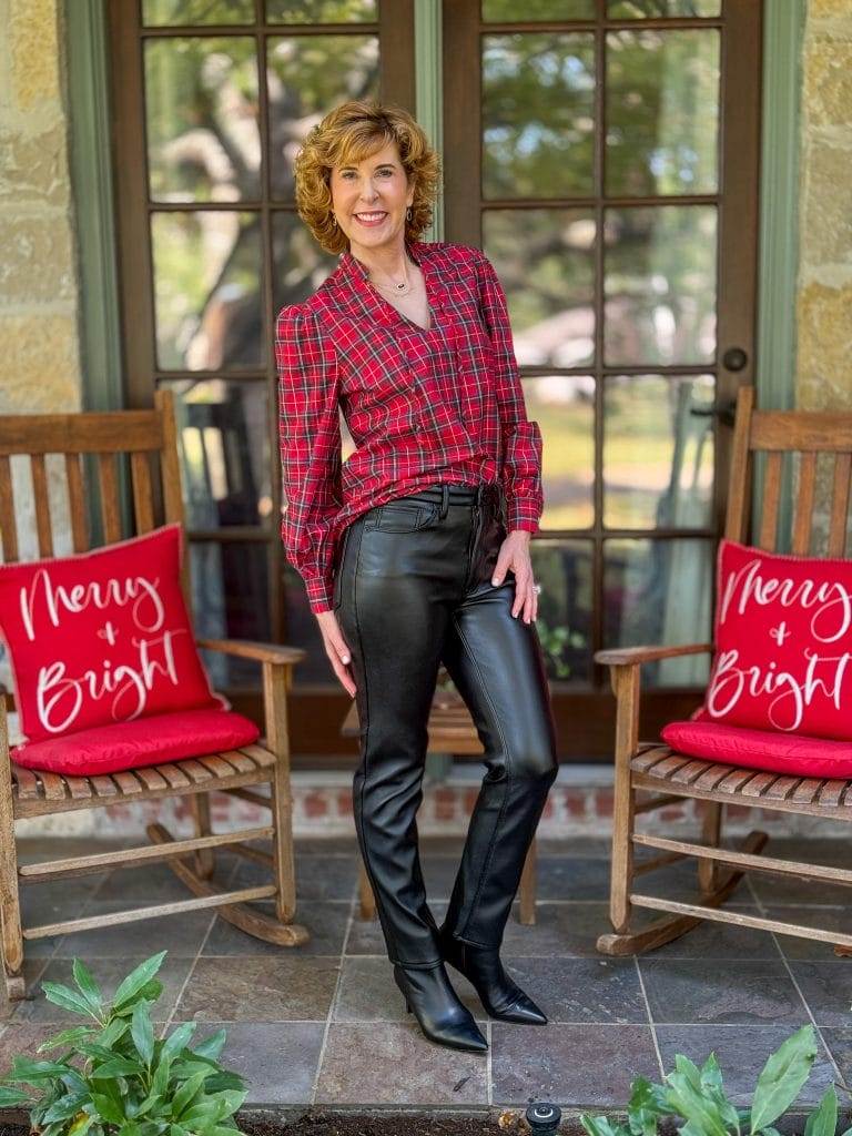 woman wearing untuckit holiday plaid top with faux leather jeans and booties