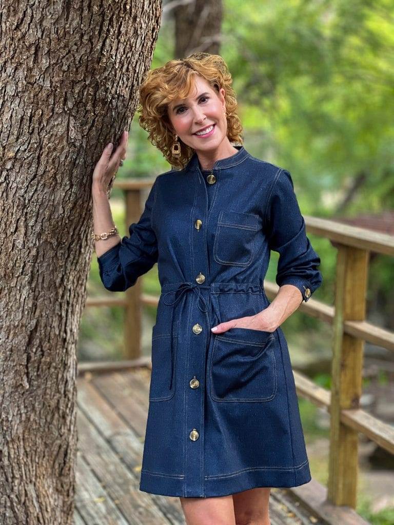 woman wearing jude connally gina denim dress standing by a tree