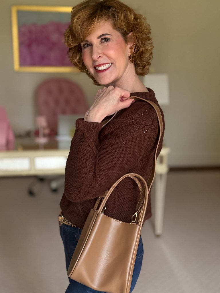 woman wearing brown cardigan and showing anthro mini hollace tote worn as a shoulder bag