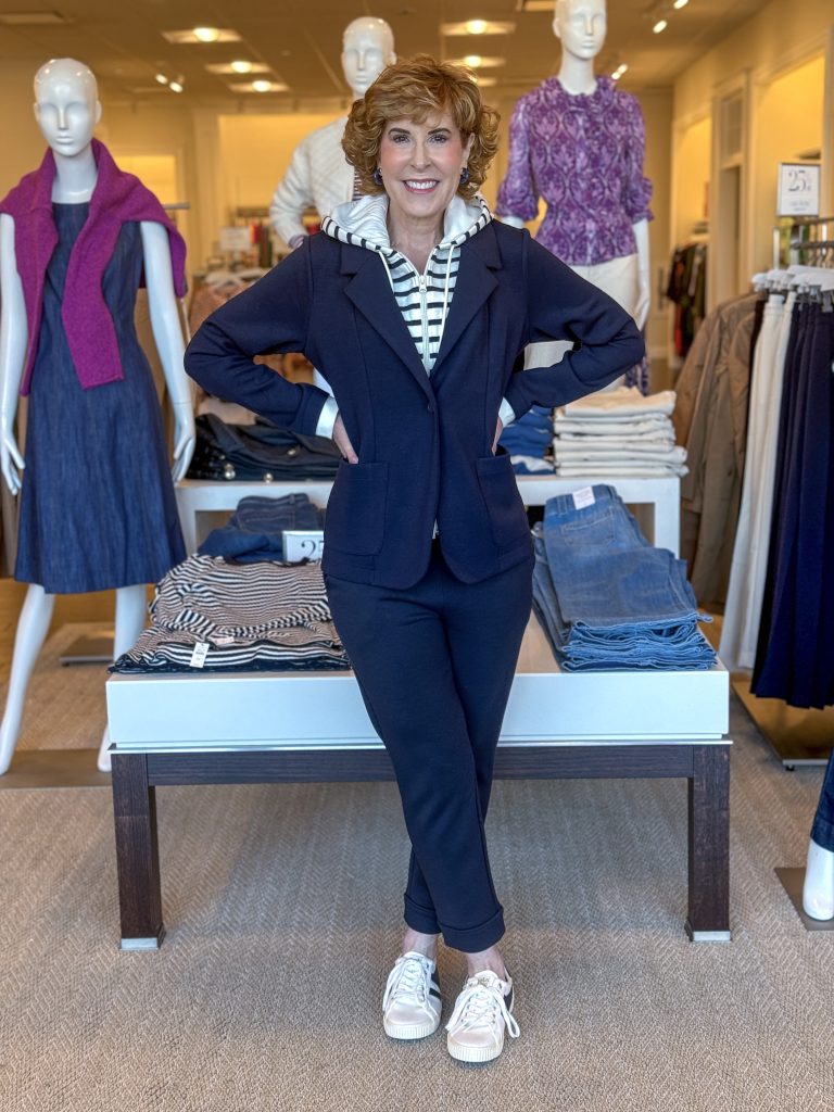 woman standing in talbots store wearing hooded blazer and knit pants in navy