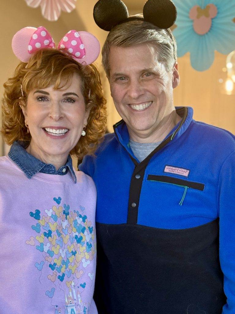 man and woman wearing mickey mouse ears at a party