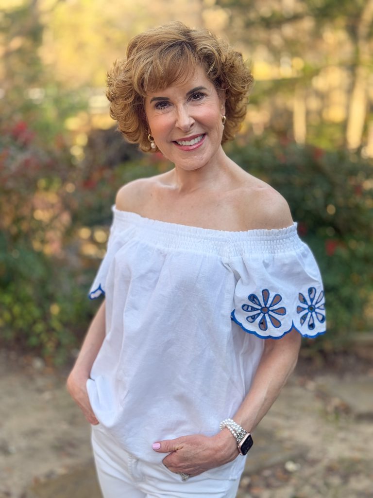 woman wearing off the shoulder white top with blue lace sleeves