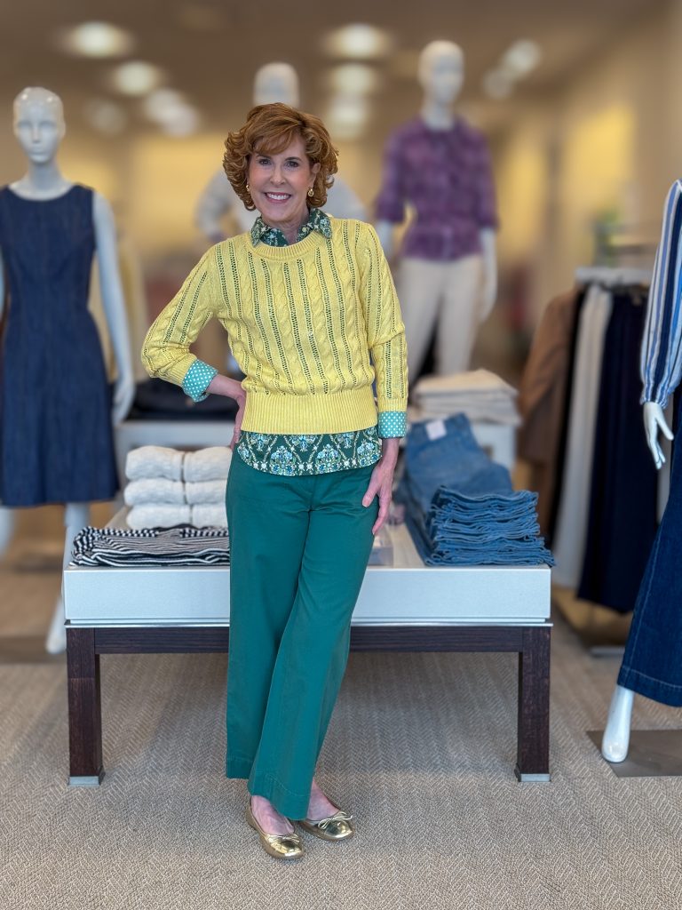 woman over 50 standing modeling green pants and a yellow sweater from Talbots showing the 2025 spring & summer style trends