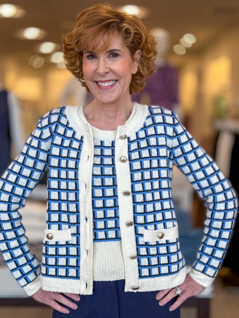 woman over 50 posing in a store wearing blue and white ladylike cardigan and tank