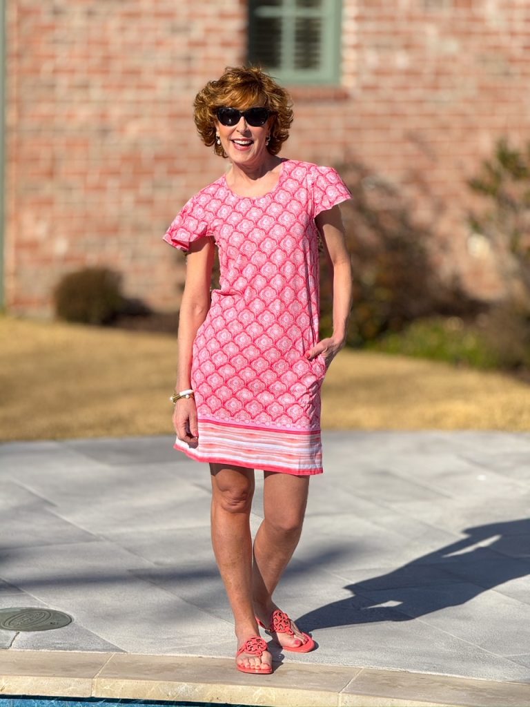 picture of woman standing next to pool wearing cabana life pink dress and pink flip flops