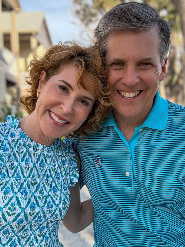 Woman and man standing next to each other with arms around each other