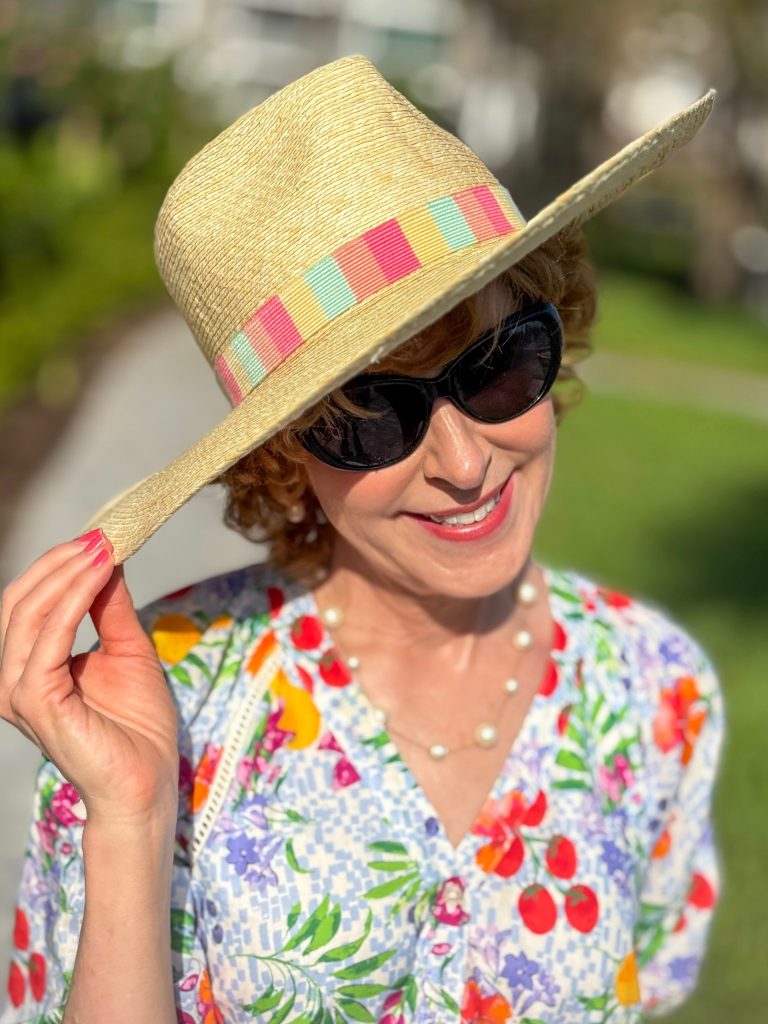 woman over 50 wearing a floral dress with talbots striped palm hat