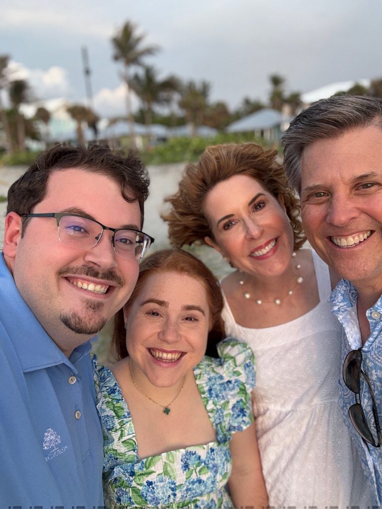 family selfie of two couples standing on beach
