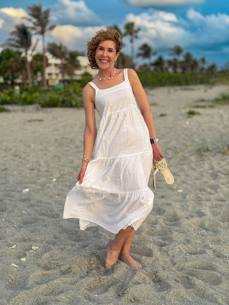 woman wearing white eyelet dress on a beach
