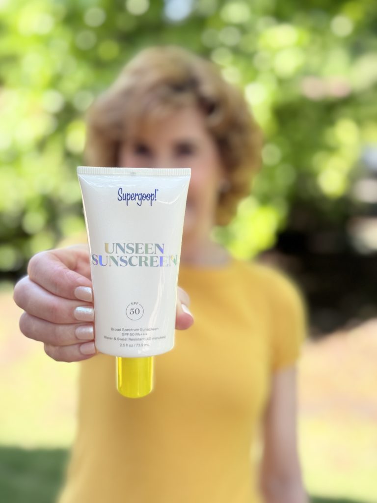 woman holding supergoop unseen sunscreen